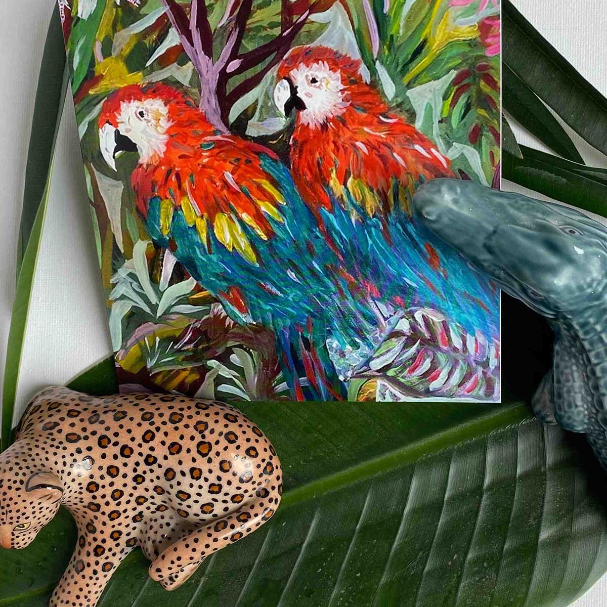 Colourful parrot painting on a leaf with a leopard figurine