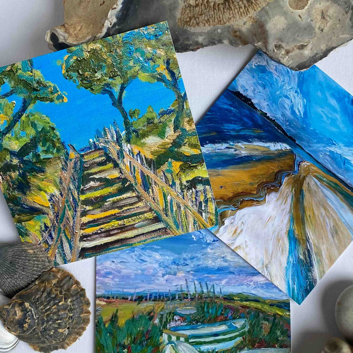 Collage of various landscape paintings with natural elements like rocks and shells.